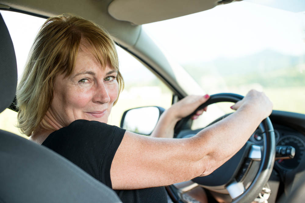 Smiling woman driving car